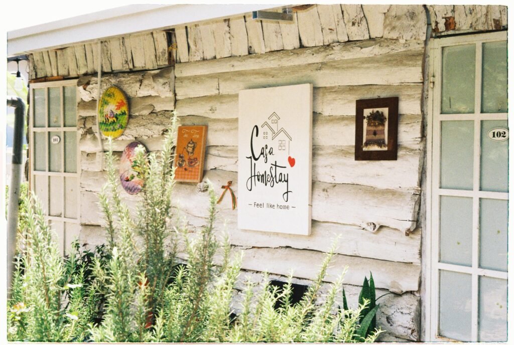 Rustic homestay exterior featuring artistic decorations, wooden textures, and welcoming atmosphere.